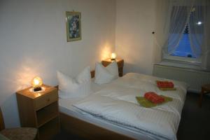 ein Schlafzimmer mit einem weißen Bett mit zwei Handtüchern darauf in der Unterkunft Pension Bodetal in Elend