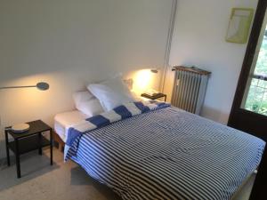 a bedroom with a bed with a blue and white striped blanket at Appartement Cassis Plage in Cassis