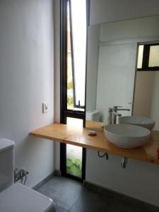 a bathroom with two sinks and a large mirror at Agua y Manto in La Pedrera