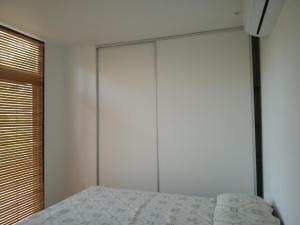 a bedroom with a bed and a large closet at Agua y Manto in La Pedrera