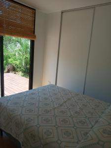 a bedroom with a bed and a large window at Agua y Manto in La Pedrera