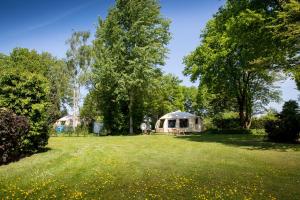 a yurt in the middle of a field with trees at Onderlandhuis 38 in Chaam