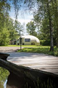 a camper is parked in a park with a bridge at Onderlandhuis 38 in Chaam
