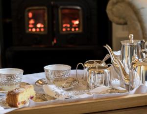 a tray with cups and tea pots on a table at Glenegedale House in Kintra