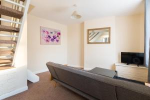 a living room with a couch and a television at Well presented 2 bedroom house - sleeps four in Leamington Spa
