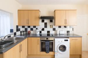 een keuken met een wastafel en een vaatwasser bij Well presented 2 bedroom house - sleeps four in Leamington Spa