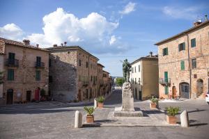 a statue in the middle of a street with buildings at Casa vacanza vicolo degli orti in Monticiano