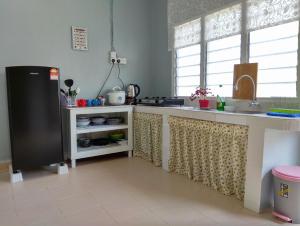 a kitchen with a sink and a refrigerator at The Hidden Gems in Pantai Cenang +7 photos