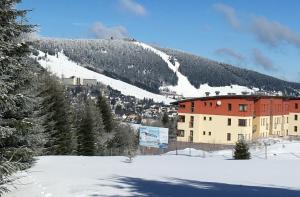 ein Gebäude auf einem schneebedeckten Berg in der Unterkunft K2 Aparthotel Klínovec Views - Mezonet Apt in Loučná pod Klínovcem