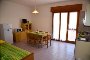 eine Küche und ein Esszimmer mit einem Tisch und Stühlen in der Unterkunft Appartamenti Mariella in Bibione