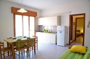 eine Küche und ein Esszimmer mit einem Tisch und Stühlen in der Unterkunft Appartamenti Mariella in Bibione