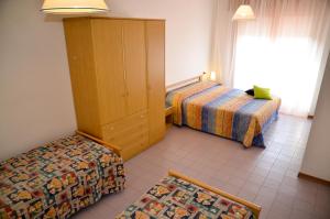 ein Hotelzimmer mit 2 Betten und einem Schrank in der Unterkunft Appartamenti Mariella in Bibione