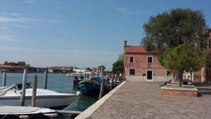 two boats are docked at a dock with a building at Comfort Murano room in Murano