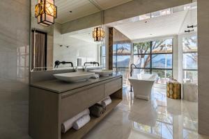 a bathroom with two sinks and a large mirror at La Petite Ferme in Franschhoek +100 photos