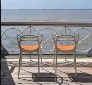 2 sillas sentadas en un balcón con vistas al océano en Le Crotoy - Entre ciel et mer, en Le Crotoy