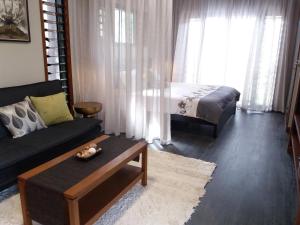 a living room with a couch and a bed at Forest Lodge: Little Villa in Agnes Water