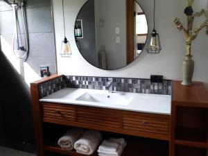 a bathroom with a sink and a mirror at Forest Lodge: Little Villa in Agnes Water