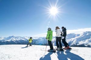 un groupe de personnes se tenant au sommet d'une piste de ski dans l'établissement Residence Ferienheim Folie, à Melago