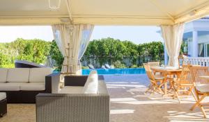 a patio with a couch and chairs and a table at White House Luxury Hospitality in Olbia
