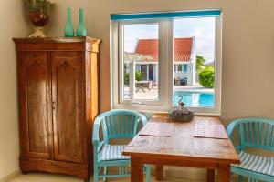comedor con mesa, 2 sillas y ventana en Aruba Boutique Apartments - Adults Only, en Noord