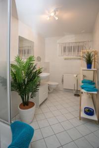a bathroom with a toilet and a plant in it at Ferienwohnung Moritzburg in Boxdorf