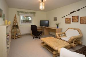 ein Wohnzimmer mit einem Schreibtisch und einem Stuhl in der Unterkunft Ferienwohnung Moritzburg in Boxdorf