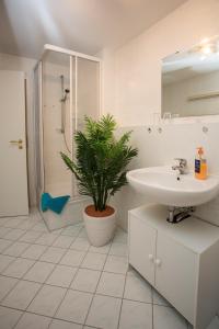 a bathroom with a sink and a potted plant at Ferienwohnung Moritzburg in Boxdorf