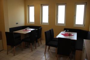 a dining room with two tables and chairs and windows at Friederike Wackler Gästehaus in Göppingen