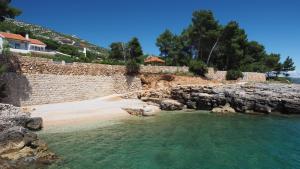 una playa con una pared de piedra y un poco de agua en Nautilus-Bay Apartments - Seaview Apartments 210, 211 - Villa Gorma en Zavala