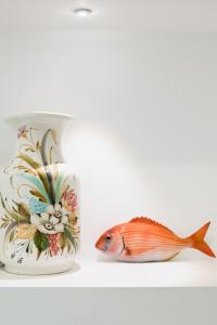 a tea cup and a fish on a shelf at Sweet Home Santa Lucia in Sorrento