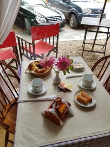 uma mesa com pratos de comida e flores em Hotel El Cisne em Villa Gesell