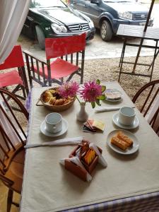 una mesa con platos de comida y flores. en Hotel El Cisne, en Villa Gesell 52 fotos más