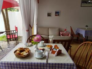 una mesa con comida y una cesta de pan. en Hotel El Cisne, en Villa Gesell