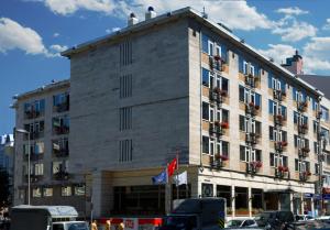 Un gran edificio con coches aparcados delante. en Hotel Buyuk Keban, en Estambul