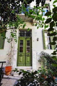 a green door on a white house with trees at Athens Quinta in Athens