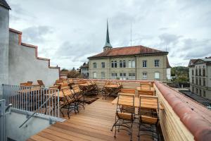 einen Balkon mit Stühlen und Tischen sowie ein Gebäude in der Unterkunft Boutique Hotel - Restaurant Orchidee in Burgdorf