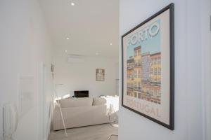 a living room with a couch and a painting on the wall at Liiiving in Porto | Center Spot Apartment in Porto