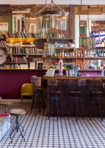 a bar with stools and shelves of books at The Independente Hostel & Suites in Lisbon