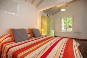 a bedroom with a large bed with a colorful blanket at Adega do Mota in Vila Franca do Campo