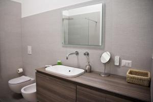bagno con lavandino, servizi igienici e specchio di A&G House a Ceglie Messapica