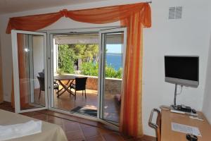 um quarto com uma porta de vidro deslizante e vista para o oceano em Nautilus-Bay Apartments - Seaview Apartments 210, 211 - Villa Gorma em Zavala