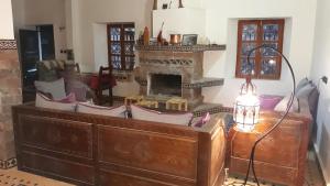 a living room with a fireplace and a dresser at Dar Ait Bouguemez in Azilal