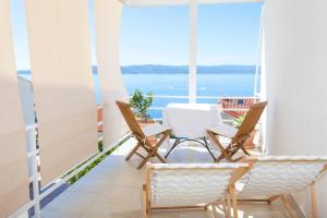 a balcony with chairs and a view of the ocean at Guesthouse Mate Ledic in Brela