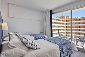 a bedroom with two beds and a large window at Carihuela Suites in Torremolinos
