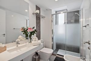 a white bathroom with a sink and a shower at Carihuela Suites in Torremolinos +37 photos
