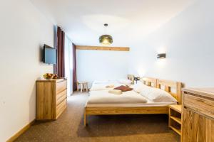 um quarto com uma cama, uma cómoda e uma televisão em Hotel Palatín em Oravský Podzámok