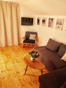 een woonkamer met een bank en een tafel met bloemen bij Ferienwohnung Bergliebe in Oberstdorf