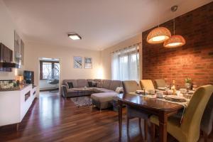 a living room with a table and a brick wall at Willa Rybaczówka z ogrodem in Puck