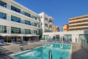 a swimming pool in front of a building at Carihuela Suites in Torremolinos