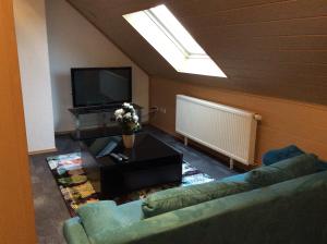 a living room with a couch and a tv at Apartment Jane in Bad Schonborn